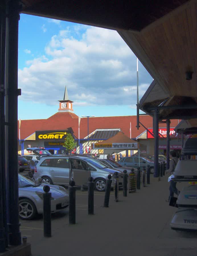Farnborough Gate Retail Park. This photograph, taken from the entrance to Halfords, shows the covered walkways outside the shops and the convenient car parking. Comet and Harveys can be seen in the distance. A more general view of Farnborough Gate Retail Park can be seen on the photograph 510906., close to the Aldi on Farnborough Gate, Farnborough